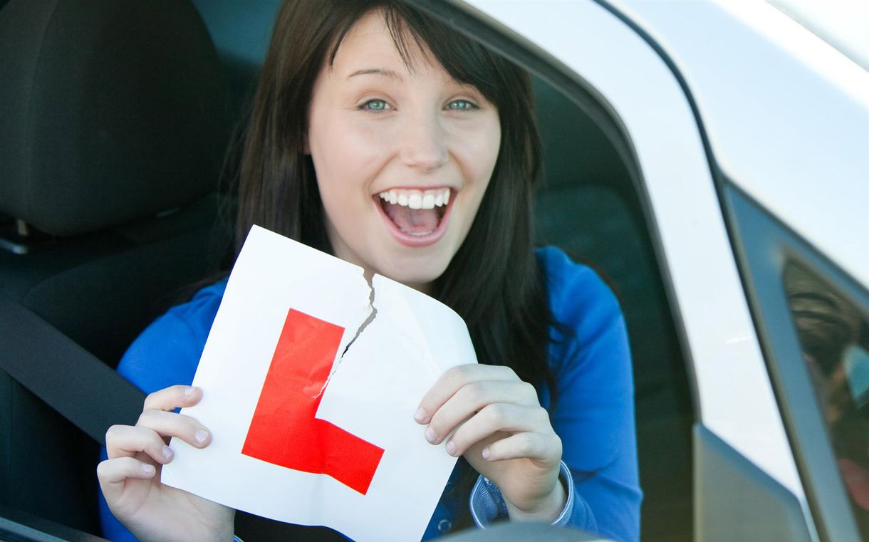 A woman ripping up a L-plate after passing her driving test